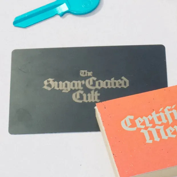 The black card carrying The Sugar Coated Cult logo