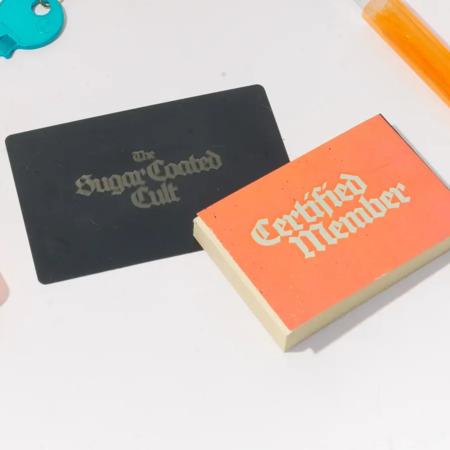 A small orange booklet lettered Certified Member, beside the black card