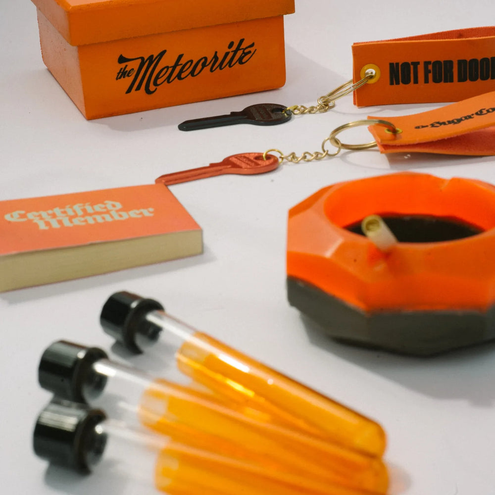 Close on the box, a keyring, the booklet, the Meteorite and the tubes
