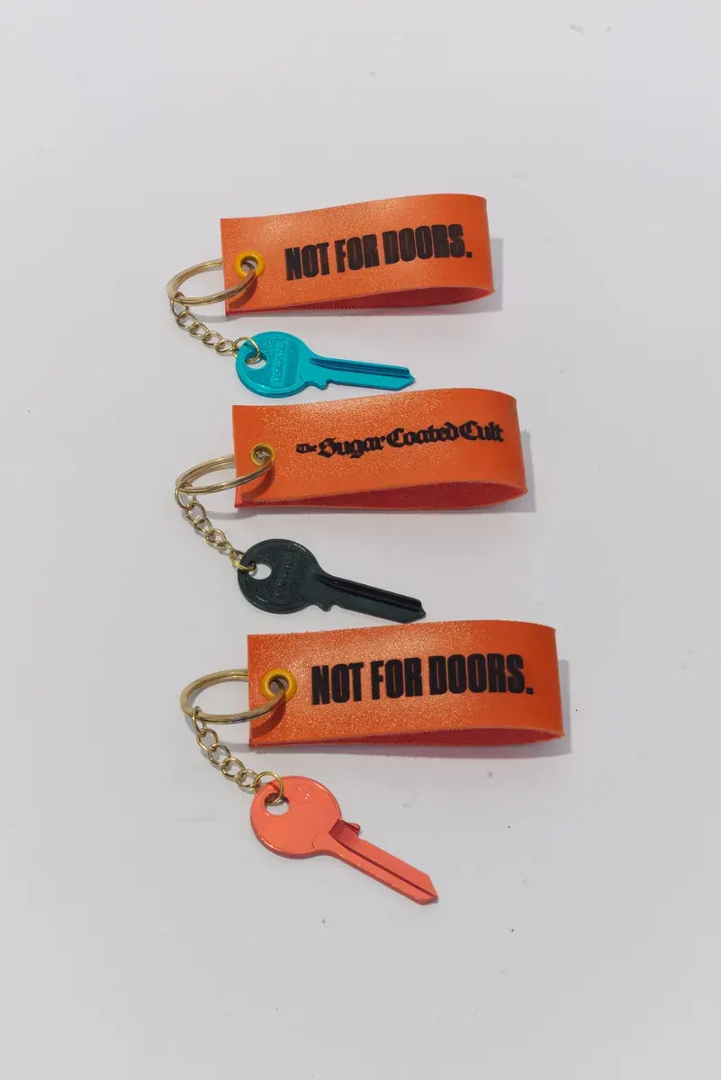 Three keyrings in a column: teal, dark and red keys