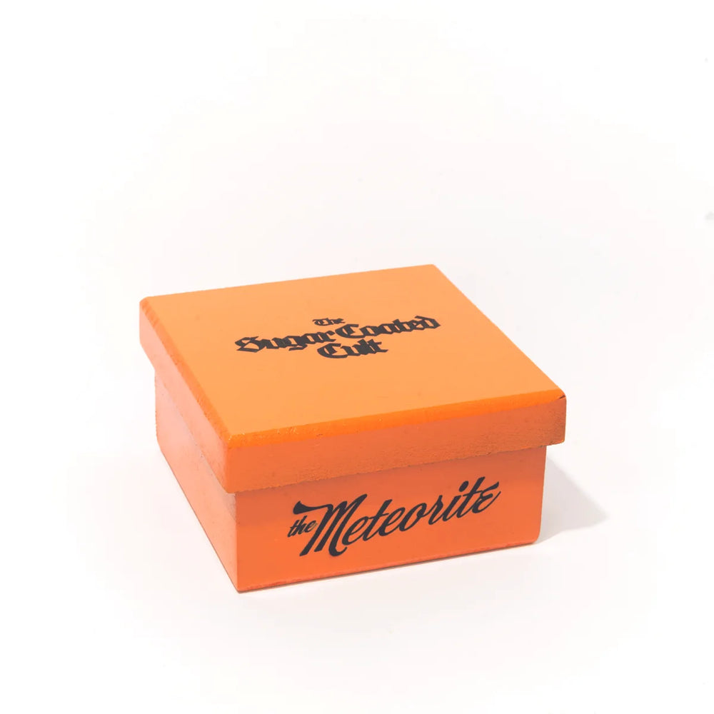 The closed orange box with The Sugar Coated Cult logo on the lid
